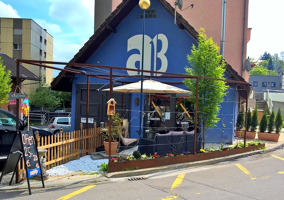 Aussenansicht des Al Capello Barbershop mit blauer Fassade und Terrasse an der Lindenstrasse 30 in Luzern