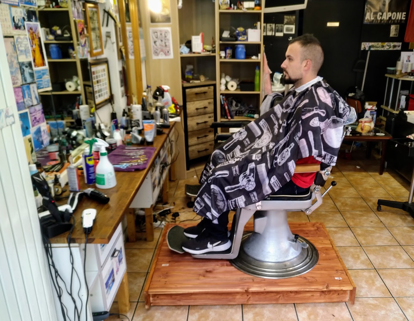 Kunde im Umhang auf altem Barberstuhl im Al Capello Barbershop in Luzern